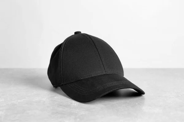 Schwarze Mütze Auf Tisch Vor Weißem Hintergrund Design Attrappe — Stockfoto