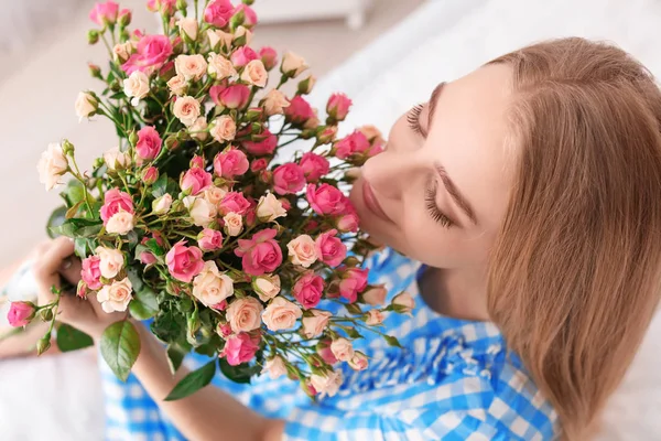 屋内で バラの花束と美しい若い女性 — ストック写真