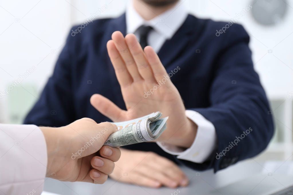 Businessman refusing to take bribe indoors, closeup