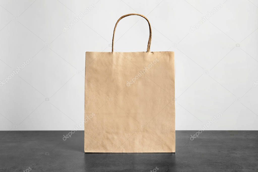 Paper bag on table against white background. Mockup for design