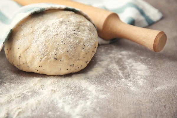 Masa cruda con semillas de amapola y rodillo en la mesa — Foto de Stock