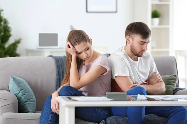 Pasangan tidak bahagia dekat meja dengan tagihan di rumah. Masalah keuangan dalam hubungan — Stok Foto