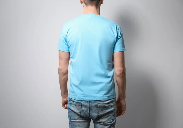 Man in blauw t-shirt op lichte achtergrond. Bespotten voor ontwerp — Stockfoto