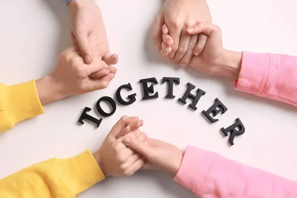 People holding hands and word TOGETHER — Stock Photo, Image