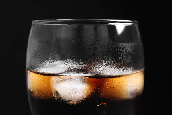 Copo de cola refrescante com gelo sobre fundo preto, close-up — Fotografia de Stock