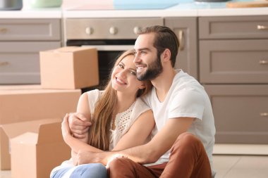 Yeni evde mutfakta katta hareketli kutular ile genç Çift