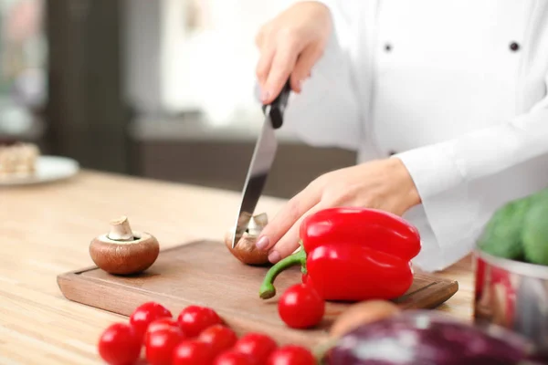 Female chef cutting vegetables in kitchen, closeup — Stock Photo, Image