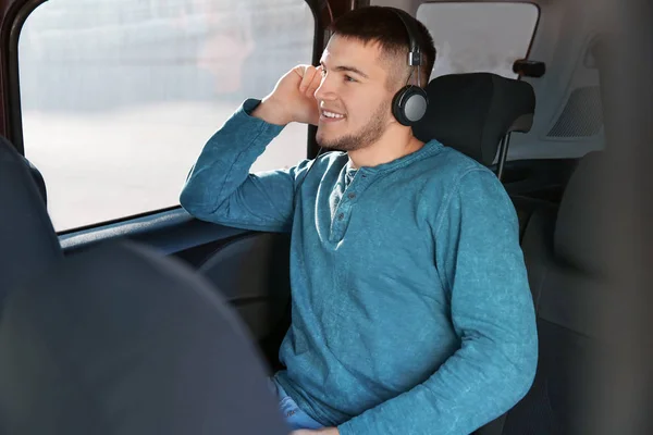 Homem ouvindo audiobook através de fones de ouvido no carro — Fotografia de Stock