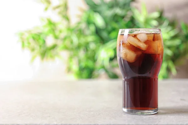 Szklankę orzeźwiającego cola z lodem na stole — Zdjęcie stockowe