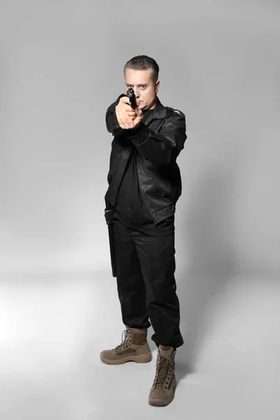Αρσενικό φρουρά ασφαλείας με πιστόλι σε γκρίζο φόντο — Φωτογραφία Αρχείου