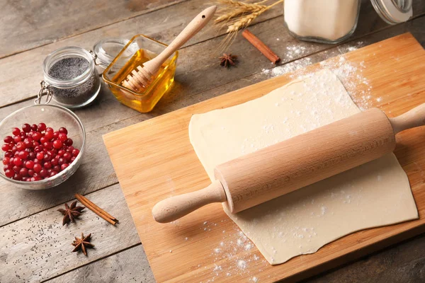 Pâtisserie feuilletée crue avec rouleau à pâtisserie sur planche en bois — Photo