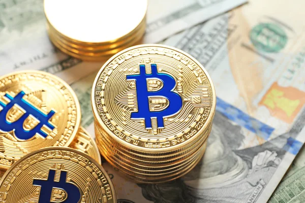 Bitcoin dorati su banconote da un dollaro, primo piano — Foto Stock