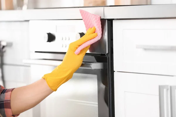 Man cleaning oven in kitchen, closeup — Stock Photo, Image