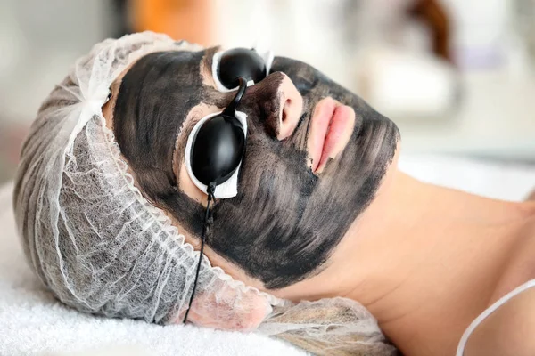 Mujer joven con nanogel de carbono en su cara en el salón. Procedimiento de descamación —  Fotos de Stock