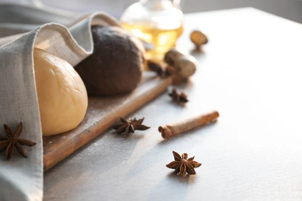 Ballen van verschillende rauwe deeg bedekt met handdoek op tafel — Stockfoto