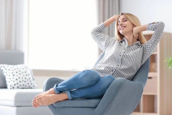 幸せな若い女の自宅の肘掛け椅子でリラックス — ストック写真