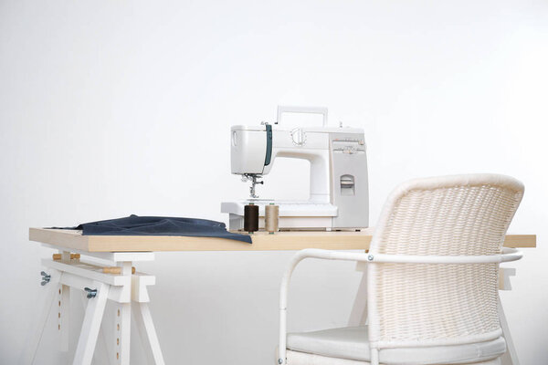 Sewing machine on table in tailor's workshop