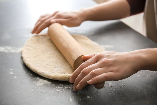 Mujer rodando masa con semillas de amapola en la mesa, primer plano — Foto de Stock