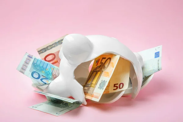 Broken piggy bank with money on color background — Stock Photo, Image