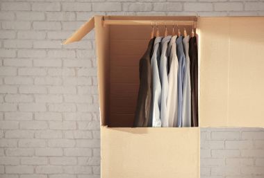 Tuğla duvar yakınındaki giysileri ile gardırop kutusu