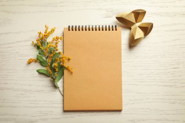 Çiçek, dekoratif kelebek ve ahşap arka plan üstünde defter