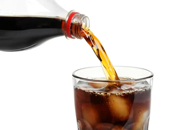 Cola pouring from bottle into glass with ice on white background — Stock Photo, Image