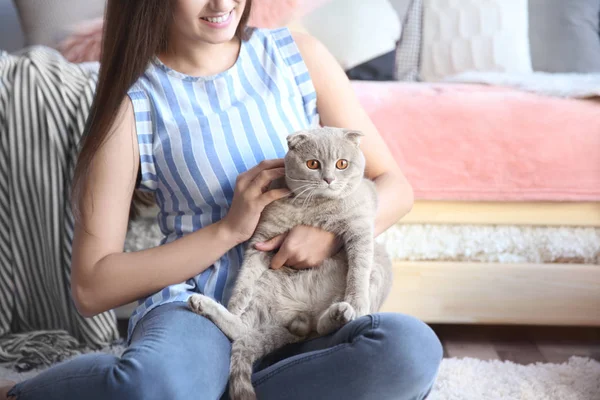 Mladá žena s roztomilý mazlíček kočka doma — Stock fotografie