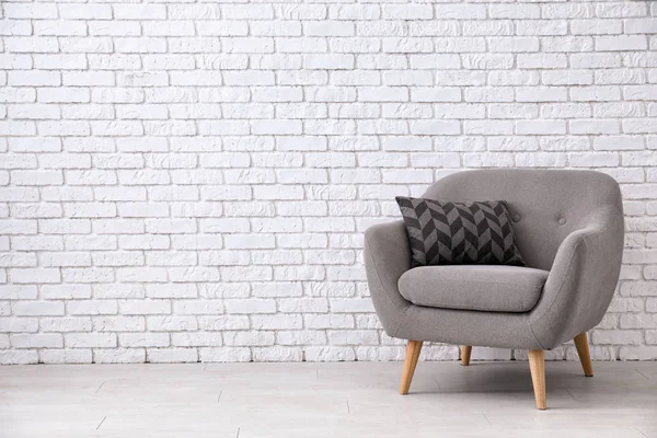 Cómodo sillón cerca de la pared de ladrillo blanco — Foto de Stock