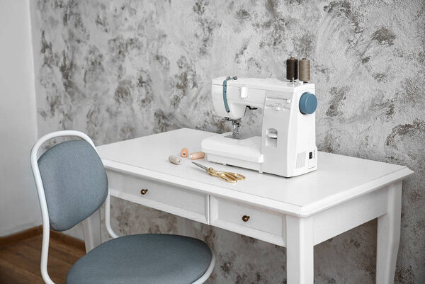 Sewing machine on table in tailor's workshop
