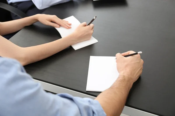Νεαρός άνδρας γράφοντας στο σημειωματάριο στο τραπέζι σε επιχειρηματική συνάντηση, κινηματογράφηση σε πρώτο πλάνο. Έννοια της ενότητας — Φωτογραφία Αρχείου