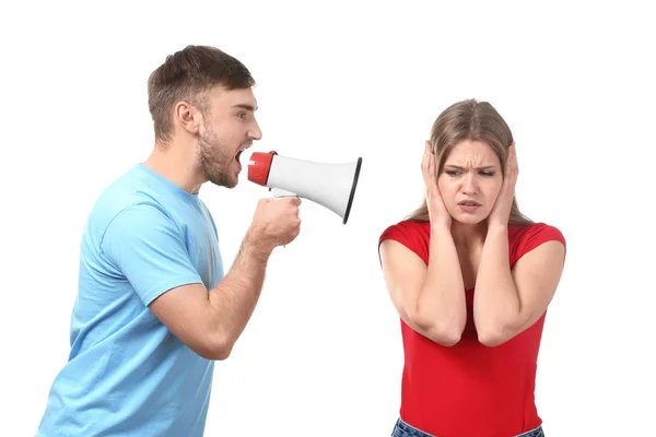 Young man shouting into megaphone at woman on white background. Problems in relationship — Stock Photo, Image
