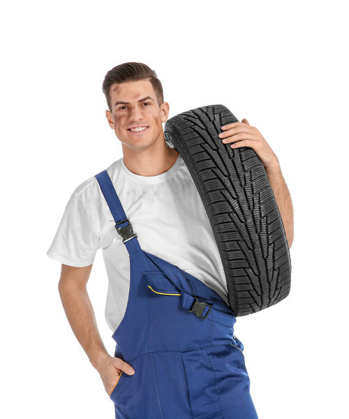 Young mechanic with car tire 