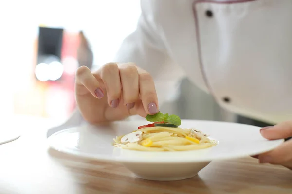 Kobieta kucharz przygotowuje smaczne makarony w kuchni, zbliżenie — Zdjęcie stockowe