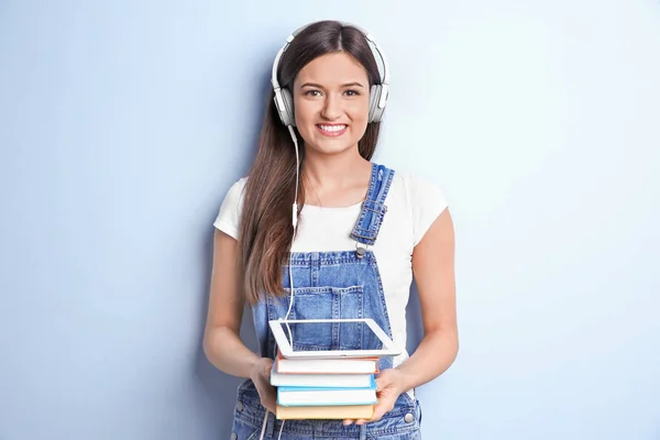 Vrouw audioboek via koptelefoon op kleur achtergrond beluisteren — Stockfoto