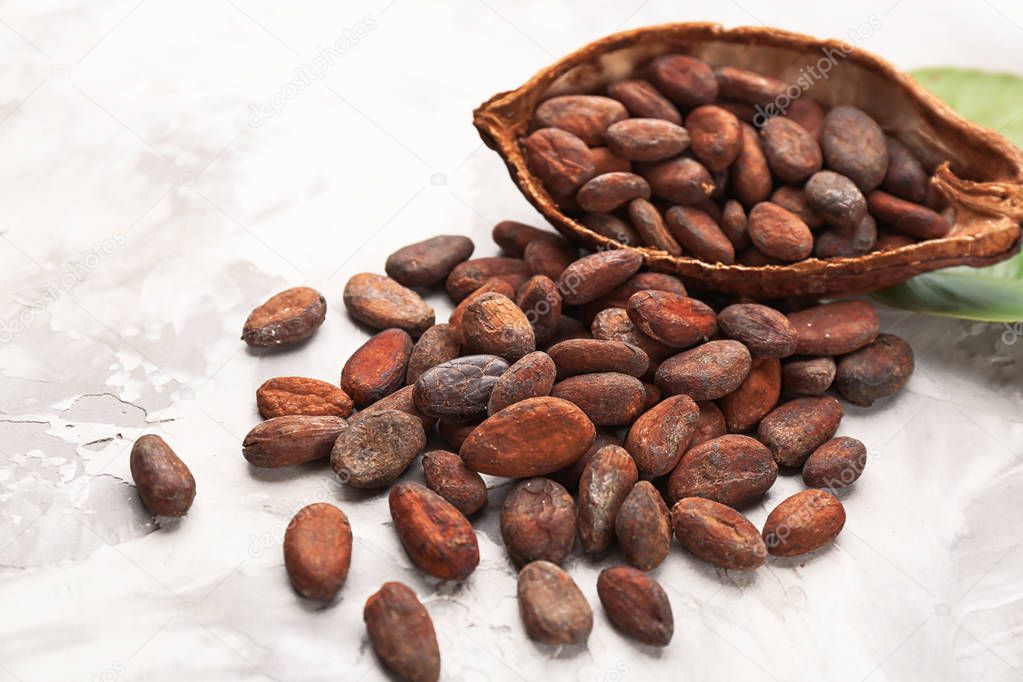 Half of cocoa pod with beans on light background