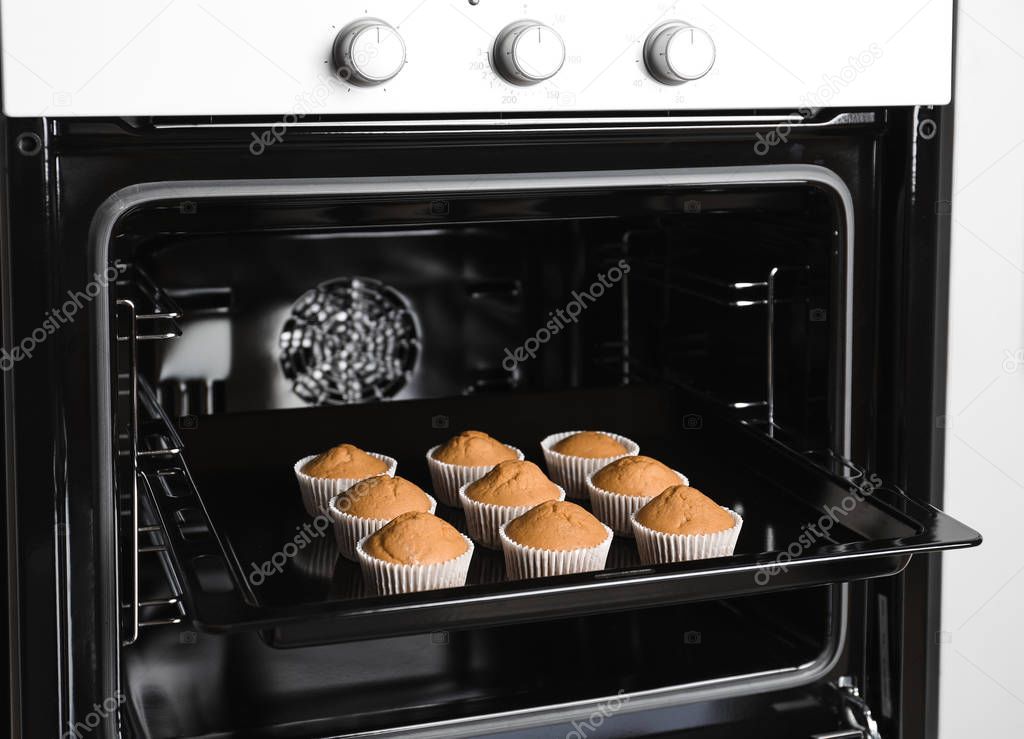Tasty cupcakes on baking sheet in oven