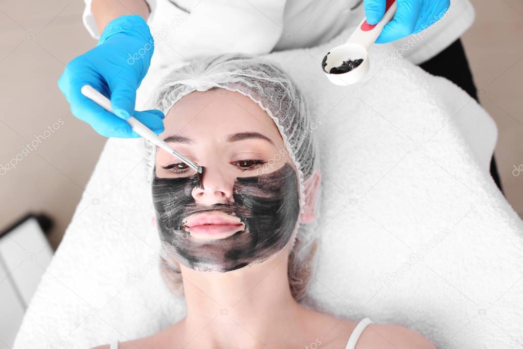 Cosmetologist applying carbon nanogel on woman's face, closeup. Peeling procedure