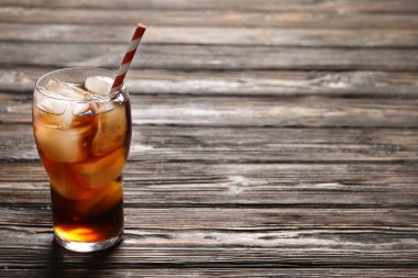 Ahşap arka plan üzerinde buzlu cola serinletici cam