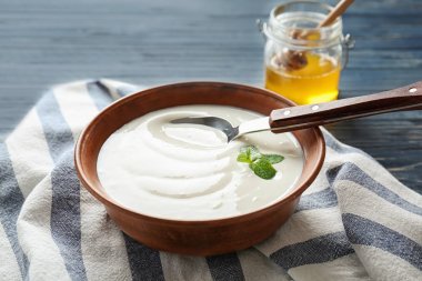 Ahşap masa üzerinde tabak lezzetli yoğurt