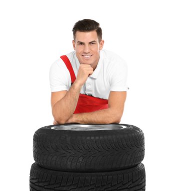 Beyaz arka plan üzerinde araba lastikleri ile üniformalı genç makinist