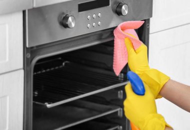 Adam mutfakta, closeup fırın Temizleme