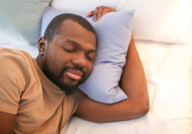 Afrika kökenli Amerikalı adam yatakta uyuyor