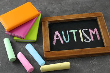 Blackboard ile kelime otizm ve tebeşir gri arka plan üzerinde parçaları
