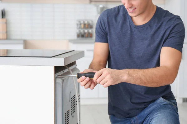 man repairing oven