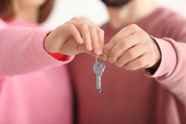 Gelukkige eigenaars houden van sleutels van hun nieuwe huis, close-up — Stockfoto