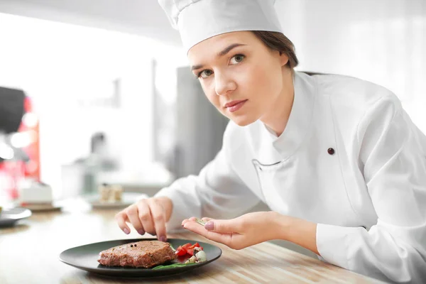 Chef femenino preparando sabroso bistec en la cocina — Foto de Stock