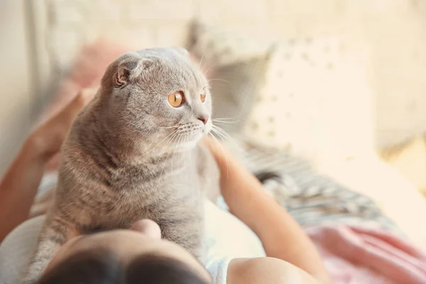 Junge Frau mit süßer Katze auf dem Bett zu Hause — Stockfoto