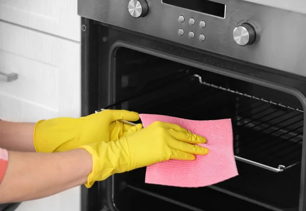 Man cleaning oven in kitchen, closeup — Stock Photo, Image