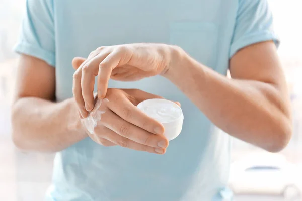 Hombre aplicando crema de manos en casa, primer plano — Foto de Stock