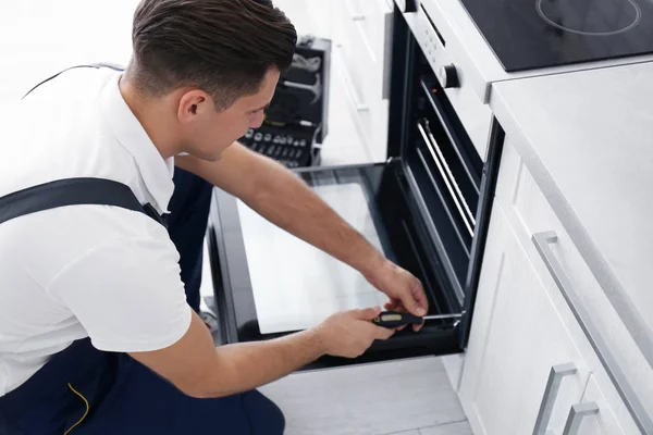 Man repairing oven — Stock Photo, Image